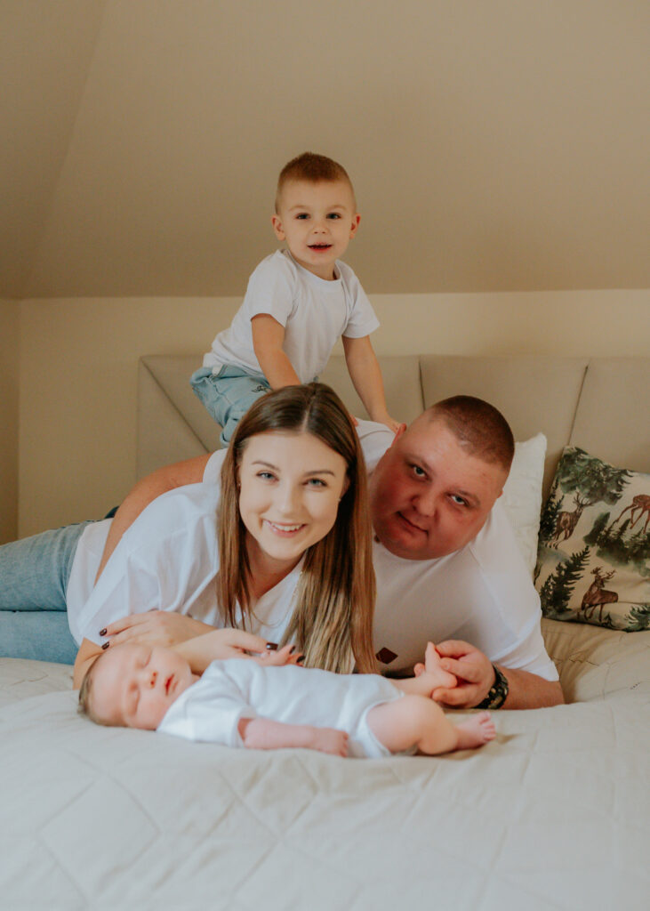 Portret rodzinny z noworodkiem na łóżku – fotograf noworodkowy Rybnik