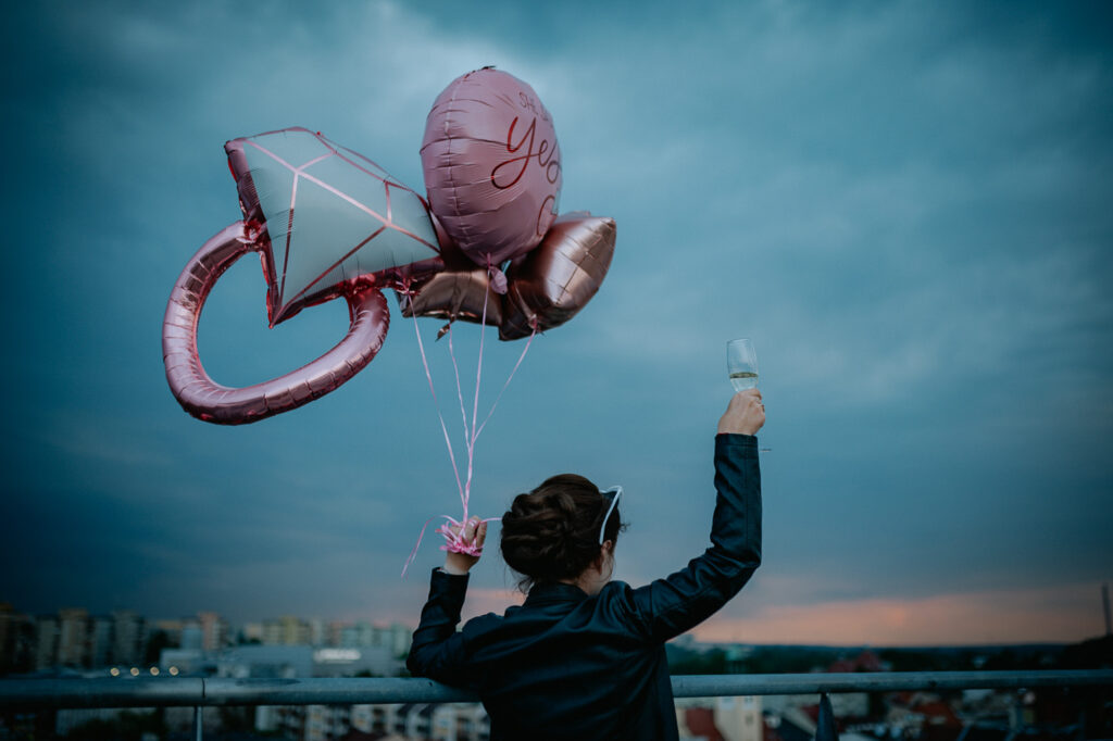 Kobieta z różowymi balonami oraz z kieliszkiem w ręku podczas wieczoru panieńśkiego w Rybniku